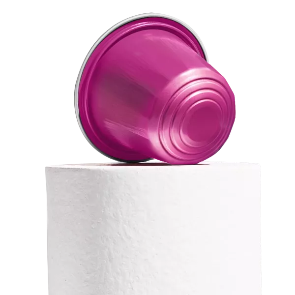 Rose pink AluSense aluminium coffee capsule displayed on a white pedestal against a white background, showing the embossed bottom detail.
