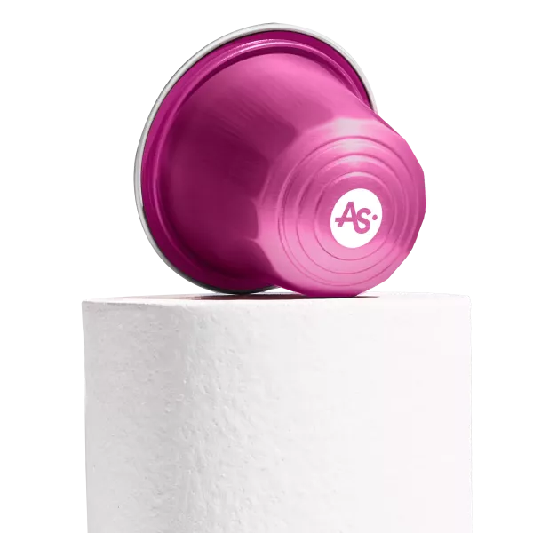 Rose pink AluSense aluminium coffee capsule with printed logo and embossed bottom detail, displayed on a white pedestal against a white background.